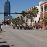 View of E Bay Street with Police Officer leading the parade and Bank of America Building at the end of the line