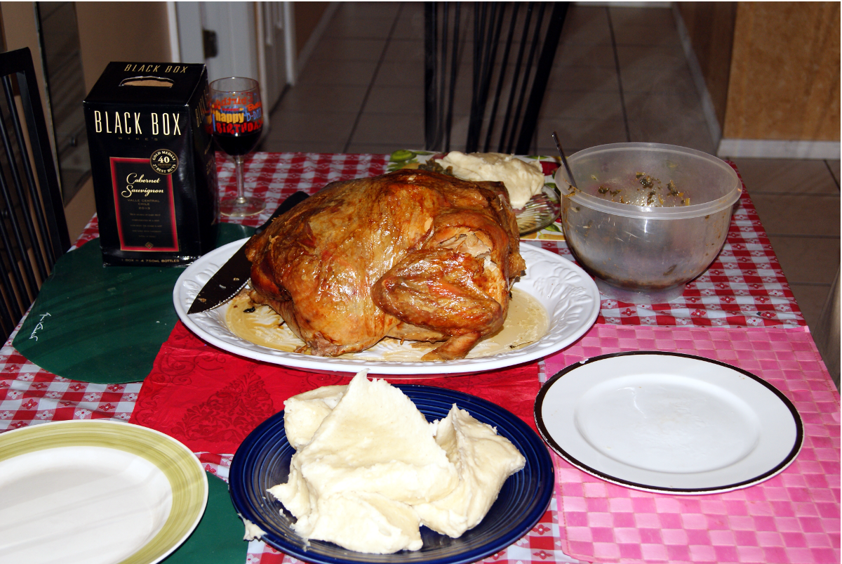 Thanksgiving dinner with Cabernet Sauvignon Wine in a Black Box, Fufu, and Collard Green.